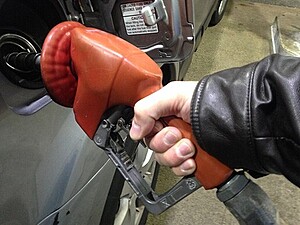 A picture of a person filling their car with gasoline at a pump.